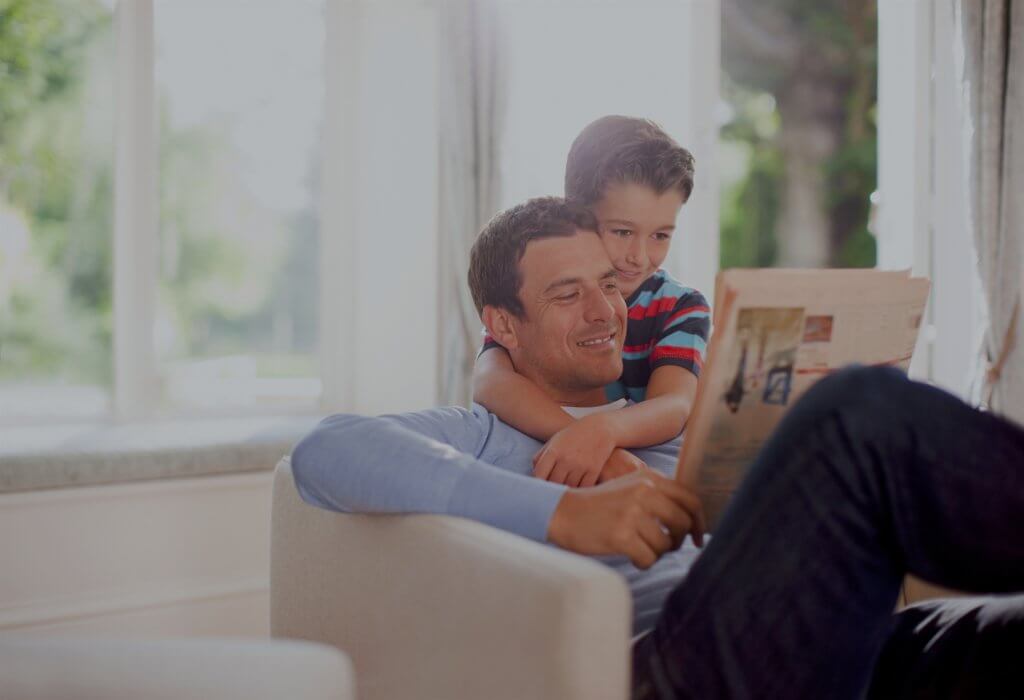 Father and son reading newspaper together