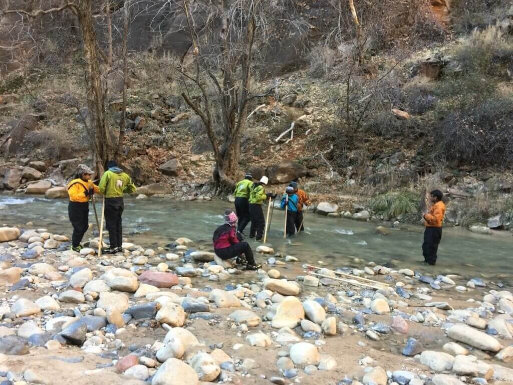 Hikers preparing for walks through the water in Zion National Park